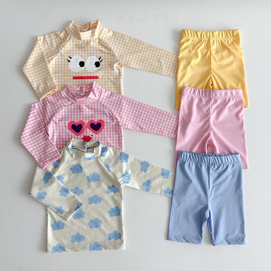 Set of children's clothing including shirts and pants on a light gray background